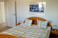 Schlafzimmer- Doppelbett mit Fußboden aus Venylparkett.